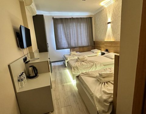 Kütahya Garden Otel odasında çift kişilik yatak ve çalışma alanı